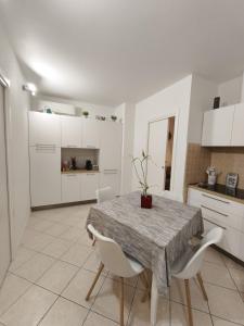a white kitchen with a table and white chairs at Atmosphere Guest House Rubiera in Rubiera +30 photos