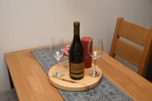 a bottle of wine on a cutting board with two wine glasses at Zlatni Javor Twins in Jahorina