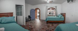 a bedroom with two beds and a hallway with arches at Casa Arcos Tepoztlán in Tepoztlán +63 photos