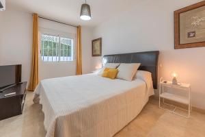 a bedroom with a large bed and a television at DOLMEN GROUP- Jardines Andalucia Banus in Marbella +53 photos