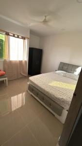 a bedroom with a large bed and a window at Apartamento Aracataca in Aracataca +4 photos