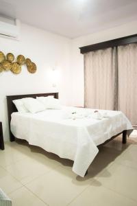 a bedroom with a large white bed with white sheets at Casa DesKanso - La Fortuna in Fortuna