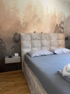 une chambre avec un grand lit avec une tête de lit dans l'établissement DivciNovaS2, à Divčibare
