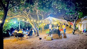 a group of people sitting around a park at night at BOHO Glamping in Ấp Phú Cát