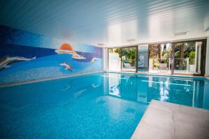 a swimming pool with a mural on the wall at Calme absolu, élégant et arboré avec piscine in Cannes