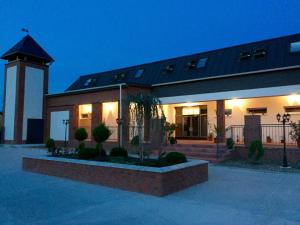 a building with a clock tower in front of it at Guest House Hodus in Vydrany