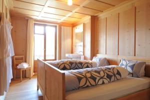 a bedroom with two beds in a room with wooden walls at Hotel Restaurant Capricorns in Wergenstein
