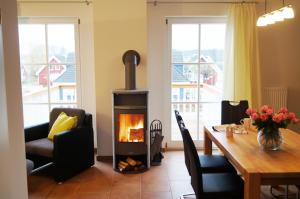 a living room with a fireplace and a dining room table at Premium Apartments in Wendisch Rietz
