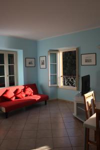 a living room with a red couch and a window at Appartamento De Angeli in Laveno-Mombello