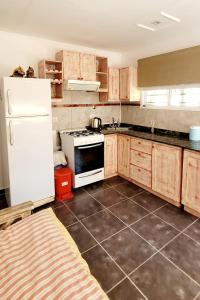 a kitchen with wooden cabinets and a white refrigerator at LaChula Casa con Piscina in Federación