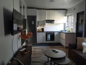 a small kitchen and living room with a couch and a table at Rena Apartments in Lilongwe