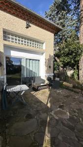 patio z ławką i domem w obiekcie Chez BEN avec tout le confort clim wifi Netflix gratuit w mieście Castres