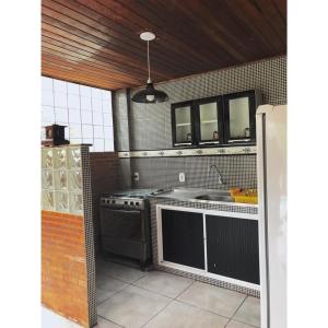a kitchen with a stove and a sink at Sobrado em Javary - 1 km do Lago in Miguel Pereira