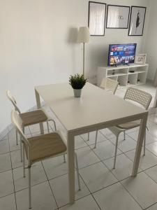 a white table and chairs in a living room at Appartement 2 pièces avec Projecteur à 100m du métro in Saint-Ouen