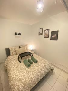 a bedroom with a bed with two green pillows on it at Appartement 2 pièces avec Projecteur à 100m du métro in Saint-Ouen