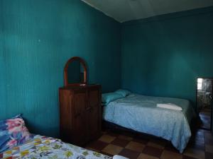 a green room with two beds and a dresser at CASA BELINDA in Santiago Atitlán