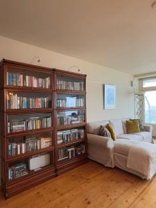una sala de estar con sofá y estanterías llenas de libros en Blue Bay Zandvoort, en Zandvoort