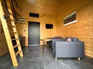a living room with two couches and a wooden wall at Jarzębinowe Wzgórze in Grzędy