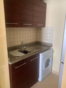 a kitchen with a sink and a washing machine at Marina Bliss-Seaside Retreat in Marsa Alam
