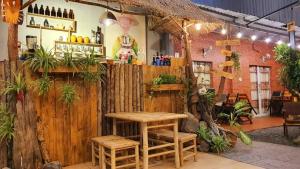 ロン・ハイにあるHomestay Hương Biển - Long Hảiの木製の柵とテーブルとスツールが備わるレストラン