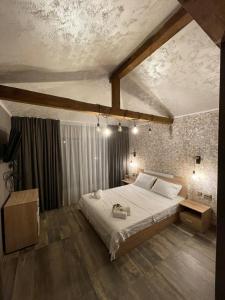 a bedroom with a large bed in a room at Къща за гости Гардения in Kamburovo