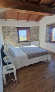 a bedroom with a bed and a stone wall at Campi dei sogni Bobbio in Bobbio