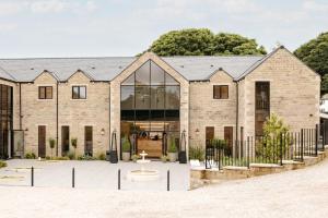 a large brick building with glass windows at Walton View Hotel in Drighlington