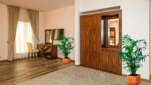 a room with two potted plants and a wooden door at Helat Hotel in Al Khobar