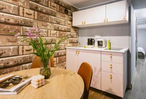 a kitchen with a table with a vase of flowers at Jana Apartment in Krakow