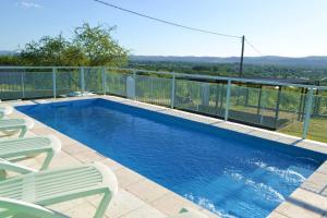 einen Pool mit zwei Stühlen und einem Zaun in der Unterkunft Complejo Las Liebres in San Lorenzo + 9 Fotos