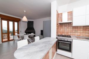 a kitchen with white appliances and a table with chairs at Seaview Terrace, Nature & Relax with TWO Private Pools - Antica Rocca Dorotea in Salerno