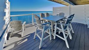a table and chairs on a deck with the ocean at Put-in-Bay Waterfront Condo #113 in Put-in-Bay