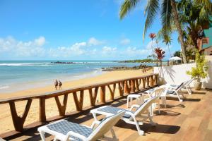a row of chairs on a balcony overlooking the beach at Pousada Casa da Sogra in Morro de São Paulo
