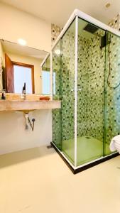 a glass shower in a bathroom with a sink at Pousada Casa da Sogra in Morro de São Paulo