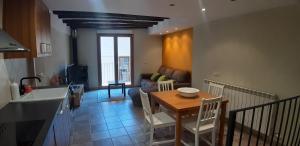 a kitchen and a living room with a table and chairs at Ca la Mariana in Organyà