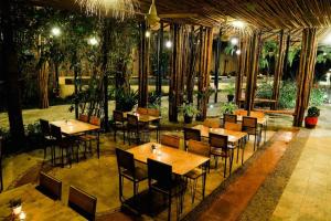 a restaurant with wooden tables and chairs and plants at Tammarene Villa in Ban Tha Khoei