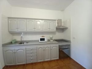een keuken met witte kasten en een magnetron bij Casa Tomás - Zona Rural in Fasnia +12 foto's