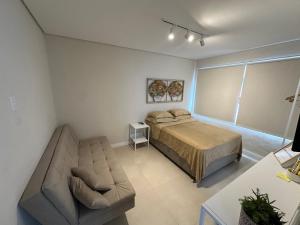 a bedroom with a bed and a couch at Apartamento Studio pé na areia in Santos