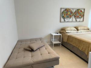 a bedroom with a bed and a couch in a room at Apartamento Studio pé na areia in Santos