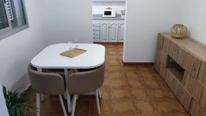 a kitchen with a white table and some chairs at Casa Tomás - Zona Rural in Fasnia