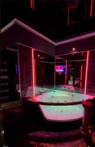 un ampio bagno con vasca con illuminazione rossa e verde di BDSM room Bydgoszcz z Balią a Bydgoszcz