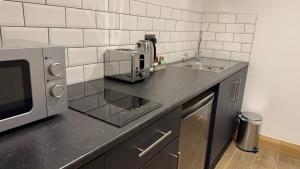 a kitchen with a microwave and a sink at Chogan City Stays in Coventry
