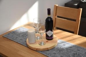 a bottle of wine and two glasses on a table at Zlatni Javor Twins in Jahorina