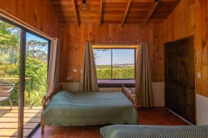 une chambre avec un lit et une grande fenêtre dans l'établissement Cabinas Capulin & Farm, à Monteverde Costa Rica