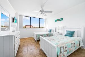 a white bedroom with two beds and a window at Our House at the Beach 201W by Beachside Management in Siesta Key +34 photos