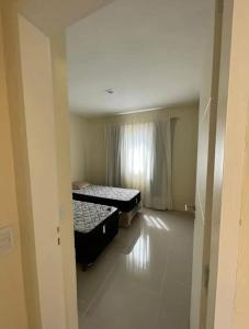 an empty room with two beds and a window at Chalet Sebastian II in Pinamar