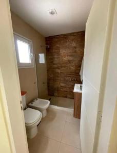 a bathroom with a toilet and a sink at Chalet Sebastian II in Pinamar