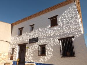 un edificio blanco con ventanas laterales en Casa Rural El Arriero, en Los Hinojosos