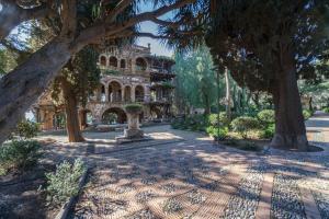 タオルミーナにあるFlower Taormina Apartmentの木々のある公園の真ん中にある古い建物
