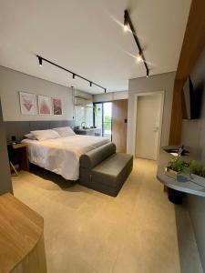 a large bedroom with a bed and a couch at LOFT 190. Hospedagem Inteligente. Campo Belo, Minas Gerais, Brasil. in Campo Belo